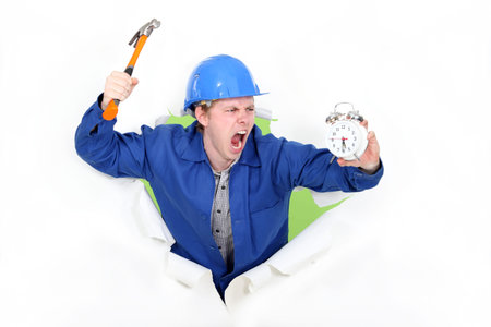 Angry man holding a hammer and an alarm clock