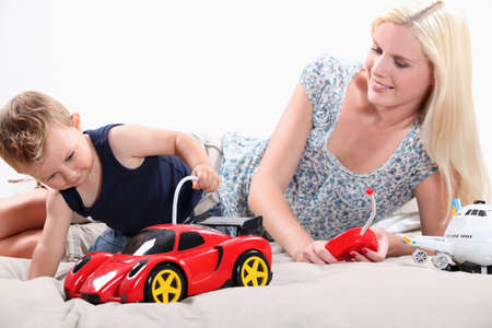Toddler and mum playing with a remote controlled sports carの写真素材