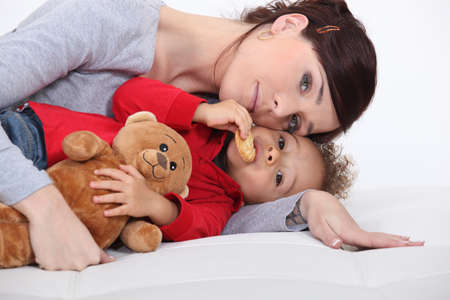 Mother and her adopted son laying on the bed の写真素材