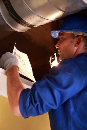 Worker repairing ventilation systemの写真素材