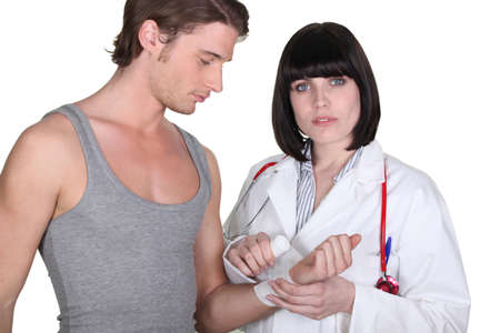 Doctor wrapping gauze around a patientの写真素材