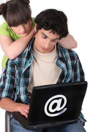 Two teenagers looking at laptop screenの写真素材