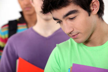 students in a line holding foldersの写真素材