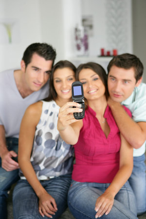 Friends taking self-portrait on the sofa