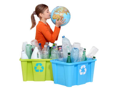 Girl recycling bottles and kissing a globeの写真素材