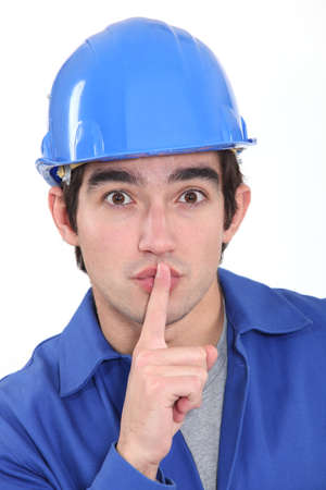 Young manual worker shushingの写真素材