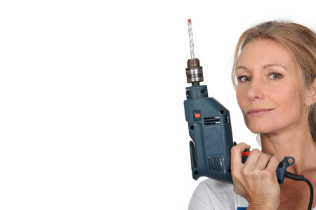 Blond woman holding electric drillの写真素材