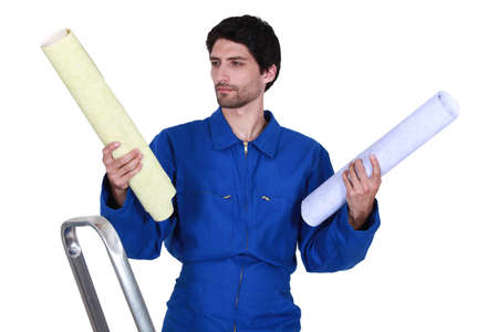 Decorator choosing between rolls of wallpaperの写真素材