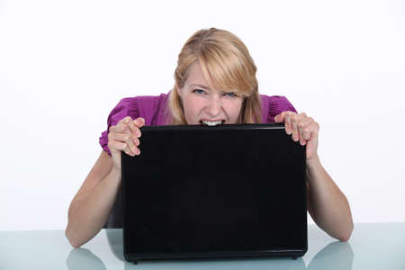 Woman biting her laptopの写真素材