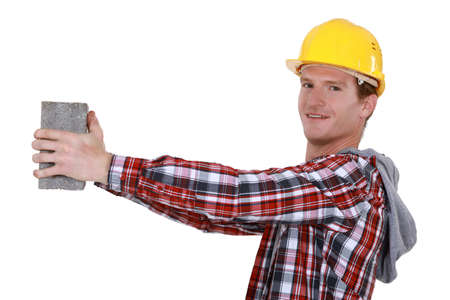 Mason holding brick at arms lengthの写真素材