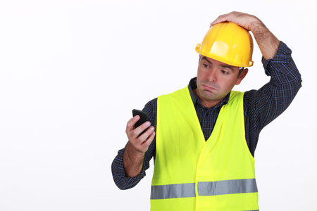 workman with fluorescent safety jacket looks puzzled