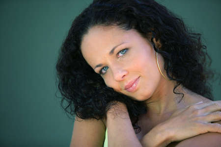 Attractive brunette posing by wallの写真素材