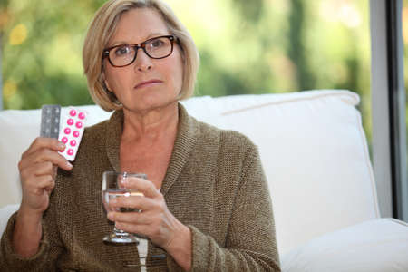 Woman about to take her medicationの写真素材