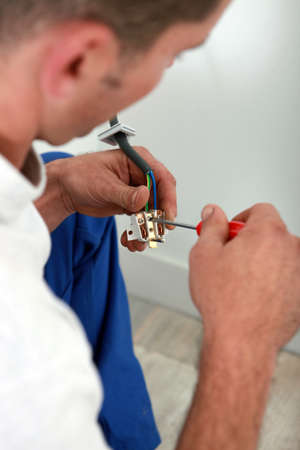 Electrician installing electrical outletの写真素材