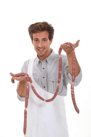 Young butcher with sausagesの写真素材