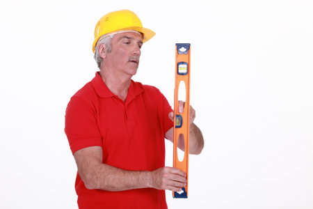 Grey-haired man holding spirit-level
