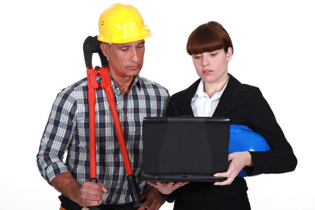 An architect and a foreman looking at a computer 
