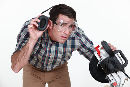 Carpenter lifting his earmuff to listen to you