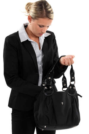 Blond businesswoman searching through her bagの写真素材