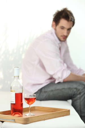 depressed man looking a wine bottleの写真素材