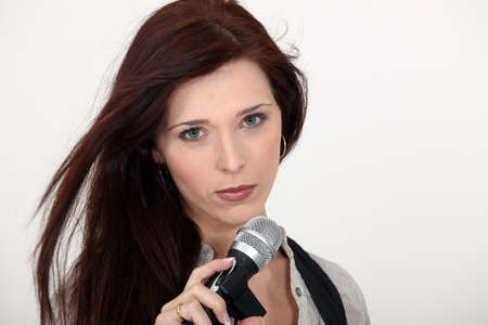 Brunette singer holding microphoneの写真素材