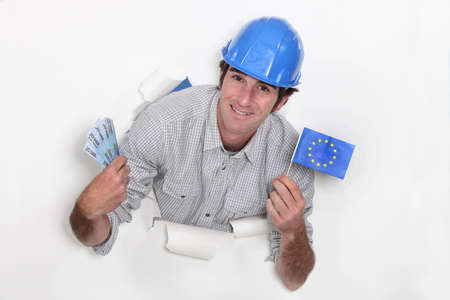 A male construction worker with cash and a European flag.の写真素材