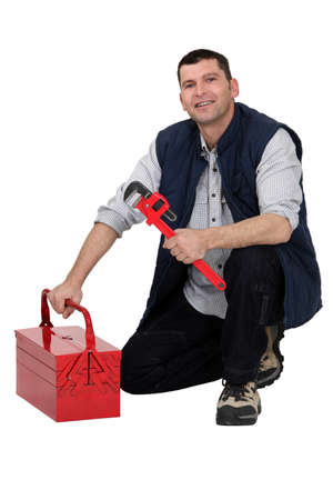 Plumber kneeling by tool-boxの写真素材