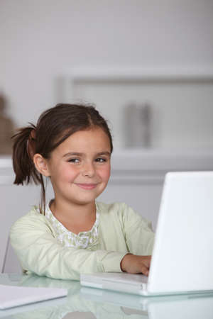 Little girl sat with laptopの写真素材
