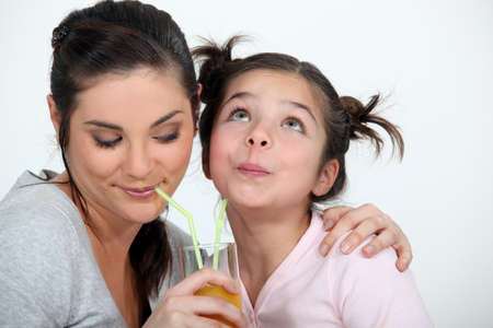 Mother and daughter sharing a drinkの写真素材