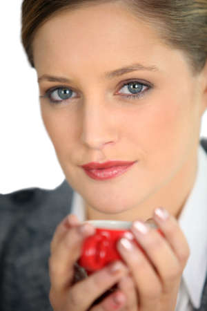 Blue eyed woman drinking a cup of expressoの写真素材