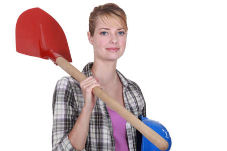 Woman with shovel over her shoulderの写真素材