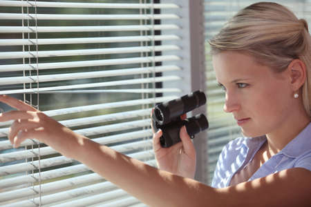 A spy peering through some blindsの写真素材