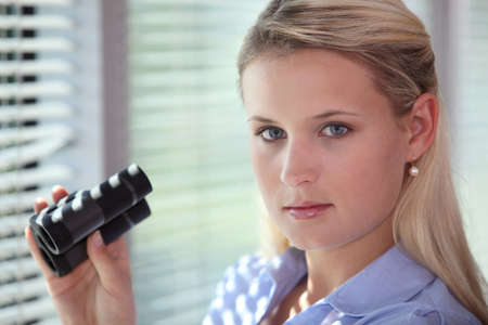 Blond woman using binocularsの写真素材