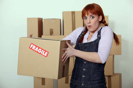 Woman carrying fragile boxの写真素材