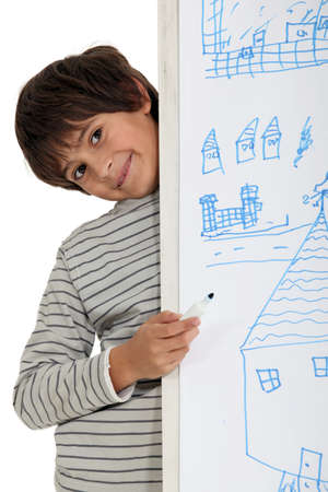 Young child standing behind his drawingの写真素材