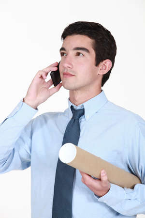 Architect stood with plans protected by cardboard tubeの写真素材