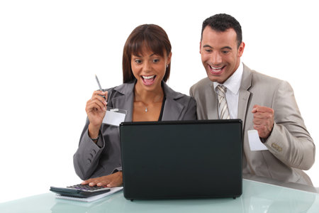Cheerful business professionals watching a video on their laptopの写真素材