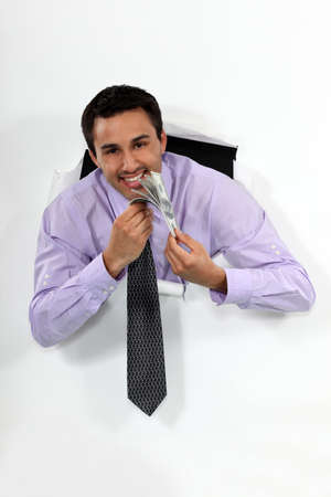 Happy businessman holding lots of moneyの写真素材