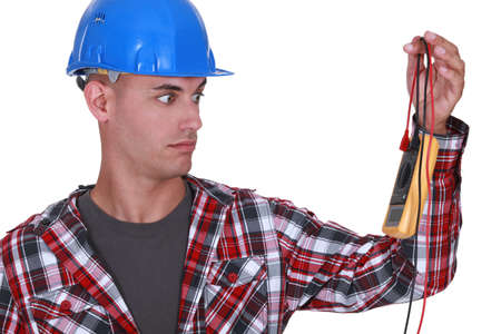 Wide-eyed tradesman staring at a multimeterの写真素材