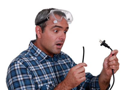 Worker looking at a cut electrical wire