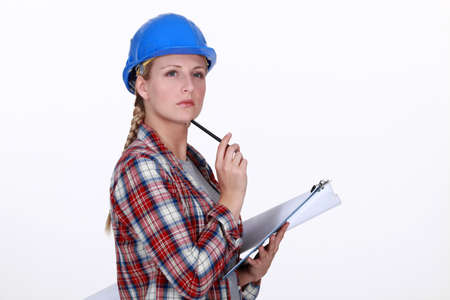 helmeted craftswoman with clipboard looking inspiredの写真素材