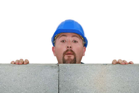 Builder peering over wallの写真素材