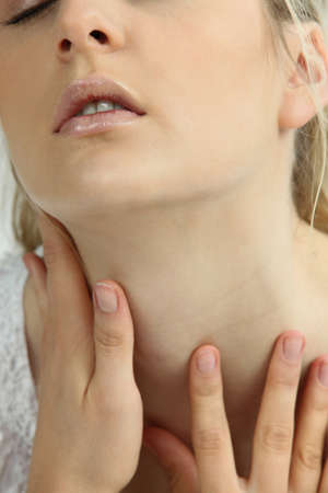 Woman touching her neckの写真素材