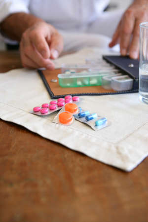 Man sorting out his medicationの写真素材