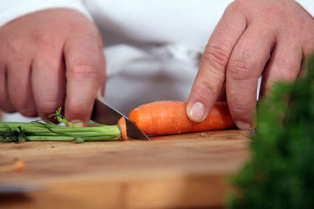 Close-up of chef slicing carrotの写真素材