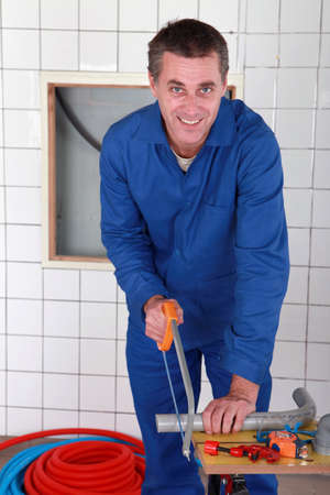 Man sawing a pipeの写真素材