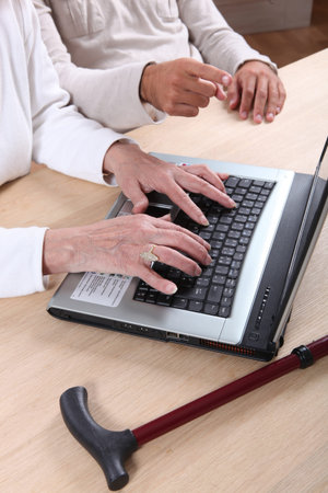 Senior woman tapping a computer keyboard