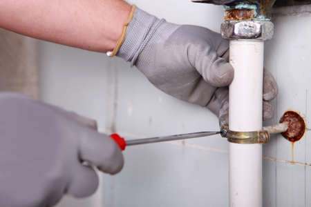 Close-up of plumber fixing bracketの写真素材