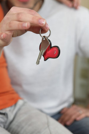 Woman holding a key on a heart keyringの写真素材