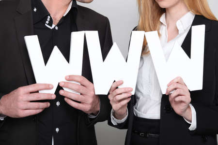 Young couple holding the letters WWWの写真素材